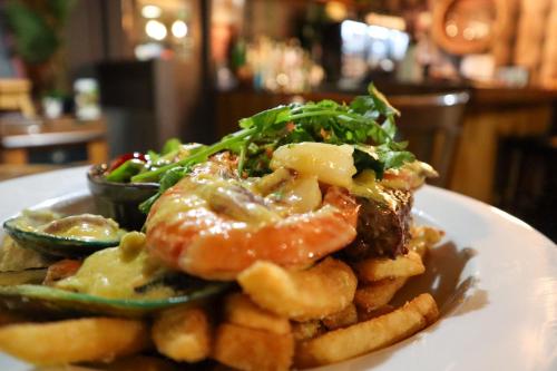 a plate of food with fries and meat and vegetables at Parklands Motorlodge & Holiday Park in Turangi