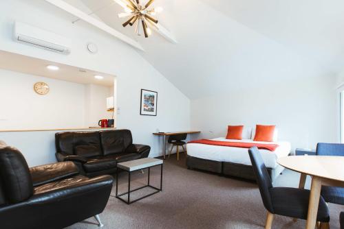 une chambre d'hôtel avec un lit, une table et des chaises dans l'établissement NORD - North Hobart Apartments, à Hobart