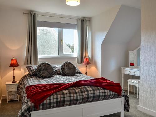 - une chambre avec un lit, deux lampes et une fenêtre dans l'établissement Anchor Cottage, à Portpatrick