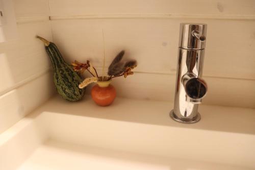 a kitchen counter with a vase and some vegetables at サウナバーベキュージャグジー完全貸し切りという贅沢大人の秘密基地#01 in Miyota