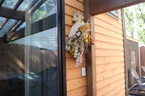 a wall of a house with a wreath on it at サウナバーベキュージャグジー完全貸し切りという贅沢大人の秘密基地#01 in Miyota