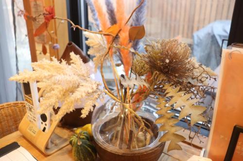 a vase with flowers in it on a table at サウナバーベキュージャグジー完全貸し切りという贅沢大人の秘密基地#01 in Miyota