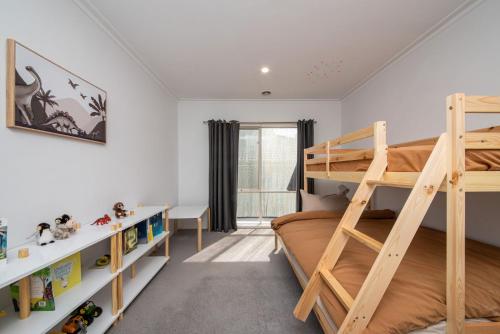 a bedroom with bunk beds and a desk at Malibu in Mt Martha with solar heated pool in Mount Martha