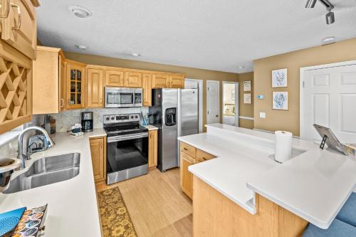 a kitchen with stainless steel appliances and wooden cabinets at 120 Creel Home away from Home for 22 at the Lake in Linn Creek