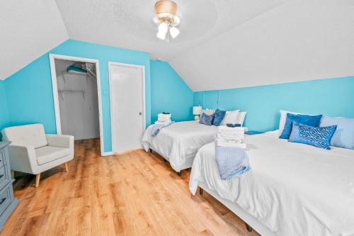 a blue bedroom with two beds and a chair at 120 Creel Home away from Home for 22 at the Lake in Linn Creek