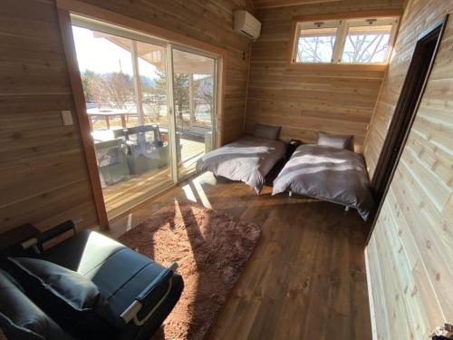 um quarto com duas camas num chalé de madeira em 薪ストーブサウナ付き250平米大型豪華フィンランドログ em Miyota
