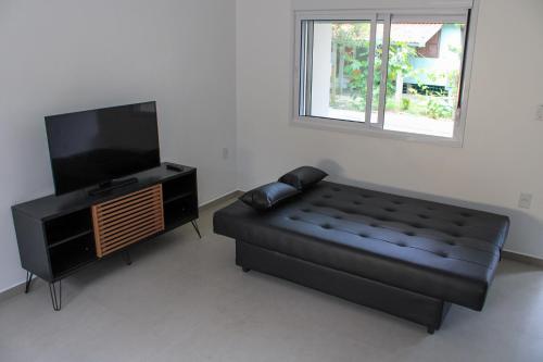 Et tv og/eller underholdning på Casa na Praia da Ferrugem com 2 vagas