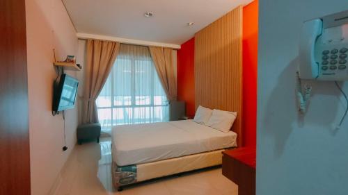 a small bedroom with a bed and a television at ANNIE KUCA in Jakarta