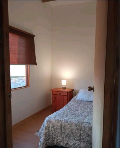 a small bedroom with a bed and a window at Casa del viento in Vicuña