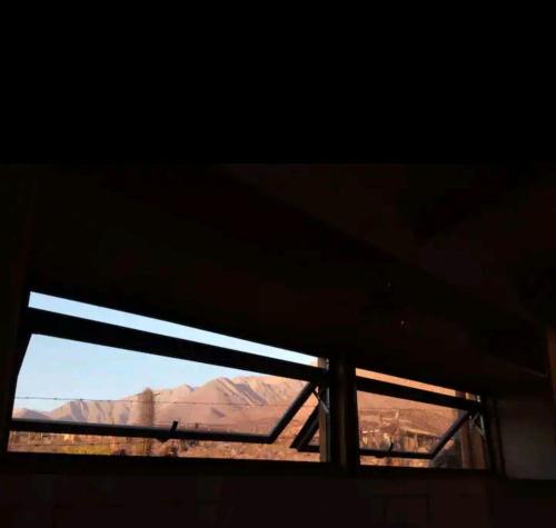 una ventana en un edificio con vistas al desierto en Casa del viento en Vicuña