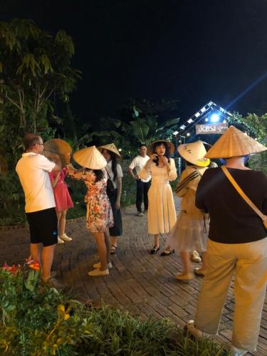 a group of people wearing cone hats on a sidewalk at Rosa Garden in Ninh Binh