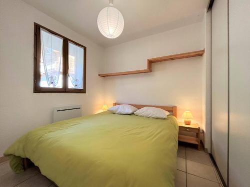 une chambre avec un lit vert et une fenêtre dans l'établissement Appartement cosy pour 4 pers, 400m pistes et village, balcon, parking et casier à skis, La Salle-les-Alpes - FR-1-330F-221, à La Salle Les Alpes
