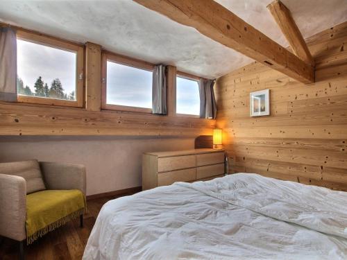 - une chambre avec des murs en bois, un lit et des fenêtres dans l'établissement Chalet 12 pers avec sauna, jacuzzi, wifi, parking, animaux admis - FR-1-455-238, à La Plagne Tarentaise