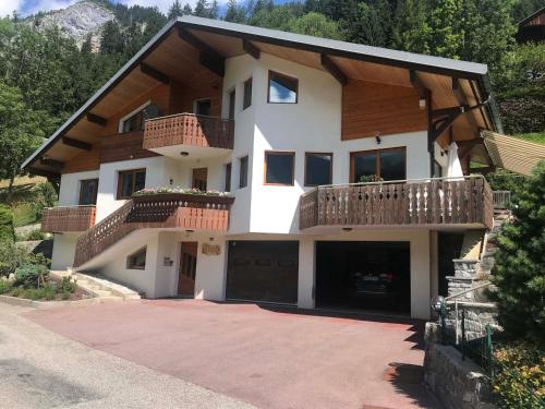 a large house with a balcony and a driveway at Appartement charmant rénové avec jardin, garage et Wifi - FR-1-692-91 in La Chapelle-dʼAbondance