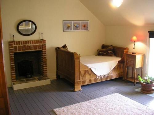 um quarto com uma cama e uma lareira em Gîte La Chapelle-des-Marais, 2 pièces, 4 personnes - FR-1-306-1258 em La Chapelle-des-Marais