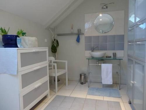 une salle de bain avec un lavabo et un miroir dans l'établissement Gîte spacieux avec jardin arboré au cœur de la Brière, proche de Guérande - tout confort inclus - FR-1-306-1258, à La Chapelle-des-Marais