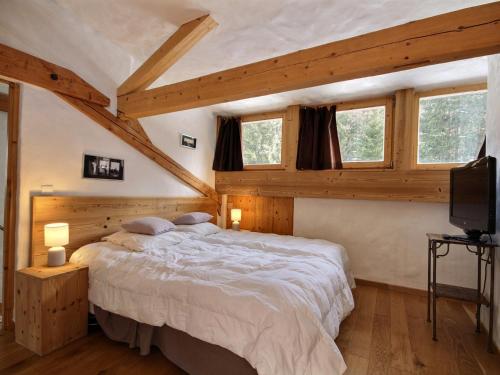 une chambre avec un grand lit dans une pièce avec des plafonds en bois dans l'établissement Chalet 12 pers, sauna, jacuzzi, animaux admis, parking - FR-1-455-239, à La Plagne Tarentaise