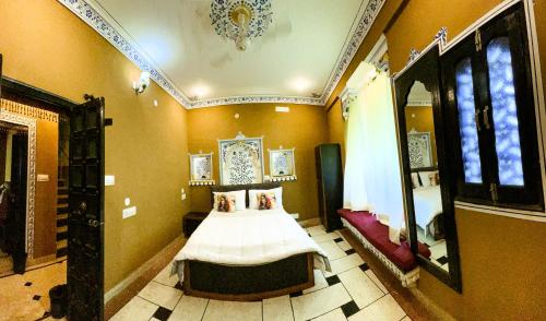 a bedroom with a bed in the corner of a room at Hotstel Udaipur in Udaipur