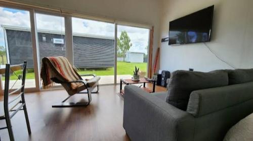a living room with a couch and a tv at Cabaña / loft in Puerto Montt