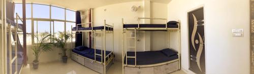 a room with three bunk beds and a window at Hotstel Udaipur in Udaipur
