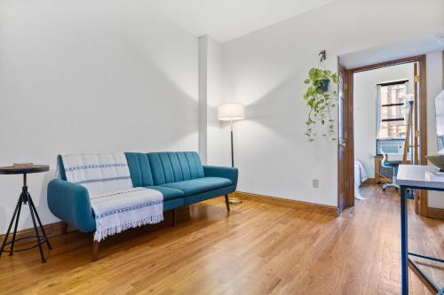 ein Wohnzimmer mit einem blauen Sofa und einem Tisch in der Unterkunft Central Living at Columbia university in New York