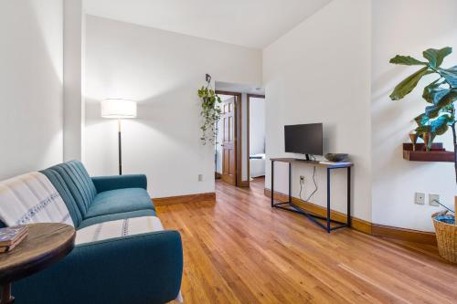 a living room with a blue couch and a tv at Central Living at Columbia university in New York