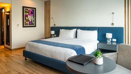 a hotel room with a large bed and a table at Wyndham Guayaquil, Puerto Santa Ana in Guayaquil