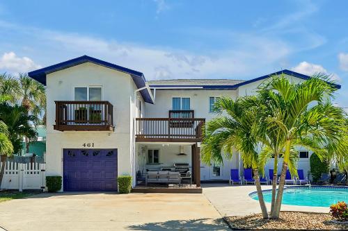 a large white house with a pool and palm trees at Villa with Beach Front Views in Cocoa Beach