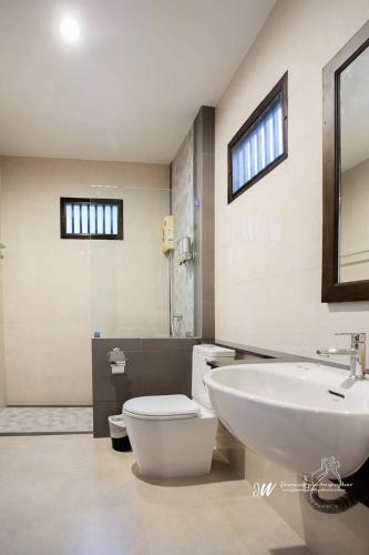 a bathroom with a white toilet and a sink at Lanta Villa Resort in Ko Lanta