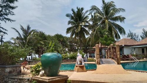 a pool at a resort with a large green vase at Lanta Villa Resort in Ban Ai Dao