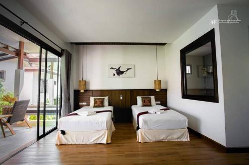 a room with two beds and a mirror at Lanta Villa Resort in Ban Ai Dao