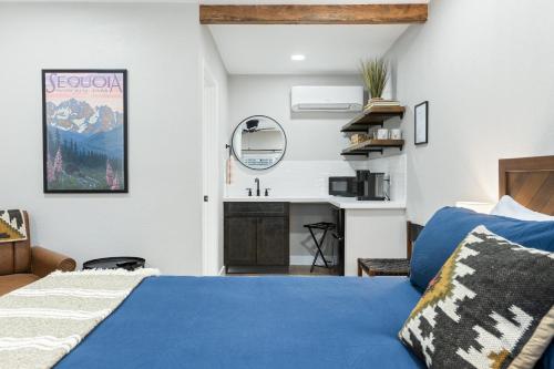 um quarto com uma cama azul e um lavatório em The Charlotte Sequoia Motel R2 em Three Rivers