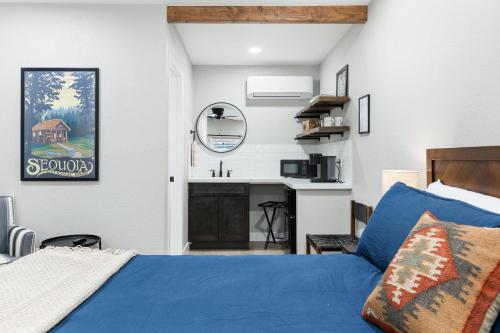 ein Schlafzimmer mit einem blauen Bett und einem Waschbecken in der Unterkunft The Heather Sequoia Motel RM 4 in Three Rivers