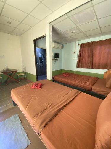 two beds in a room with a mirror at Bansuan Inthanon Eco Resort in Chom Thong