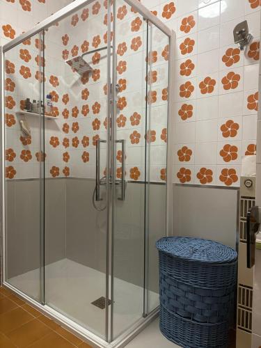 y baño con ducha de cristal con taburete azul. en AURORA GARGEN IN CENTRO, en Trieste