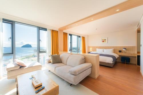 Habitación de hotel con cama y sofá en Hotel Fine Jeju en Seogwipo