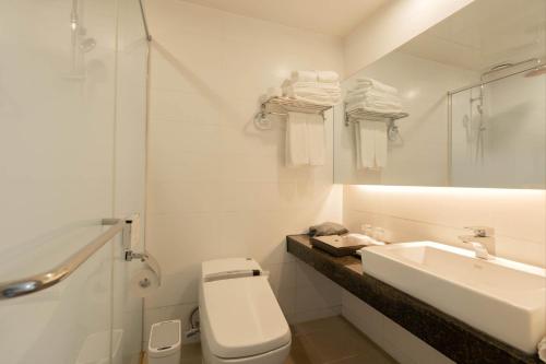 a white bathroom with a sink and a toilet at Hotel Fine Jeju in Seogwipo