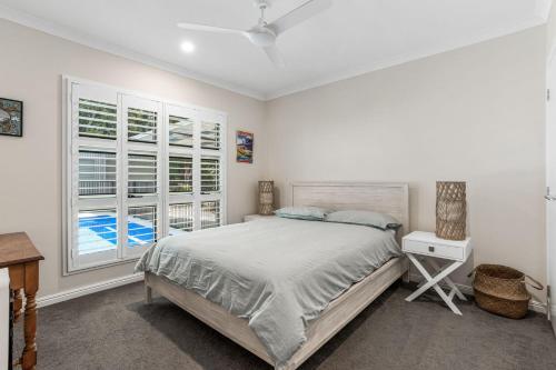um quarto branco com uma cama e uma janela em 11 Esprit Drive - Rainbow Shores. Swimming Pool - Wifi - Walk to beach em Rainbow Beach