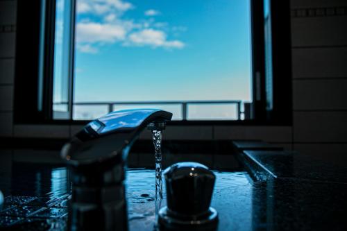 a sink with water coming out of a faucet at the salon 伊豆高原 Hotels & Resort in Ito