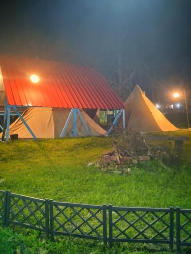 a group of tents in a field at night at AWANAZ FARM GLAMPING in Jitra