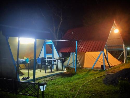 un groupe de tentes dans un champ la nuit dans l'établissement AWANAZ FARM GLAMPING, à Jitra