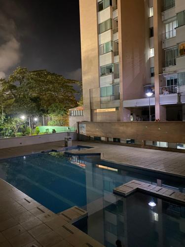una piscina frente a un edificio por la noche en Apartamento completo, en Ibagué