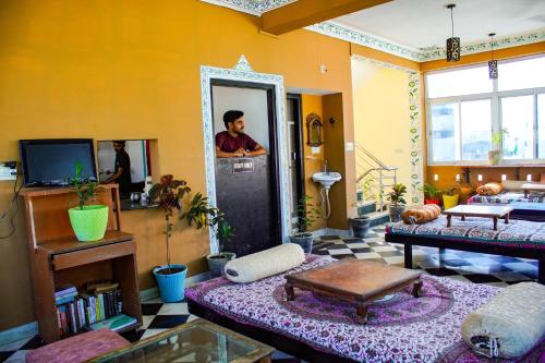 a living room with a table and a tv in it at Hotstel Udaipur in Udaipur