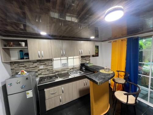 a small kitchen with a refrigerator and a counter at Posada Ashanty in Providencia