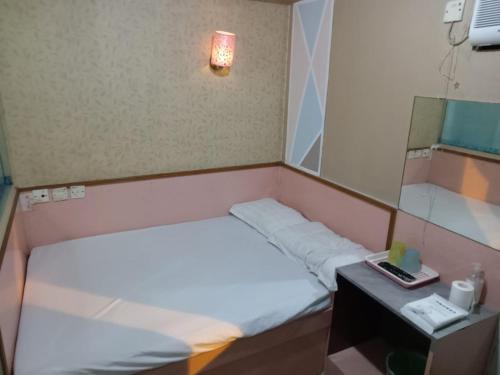 a small room with two beds and a mirror at 嘉湖旅館 in Hong Kong