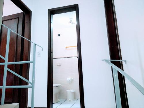 a bathroom with a toilet and a glass door at Triplex White em Caiobá-Matinhos-Pr a 200 mt do mar in Matinhos