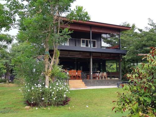 a house with a porch and some flowers in the yard at My Home @ Wang Yao in Ban Tha Sai (1)