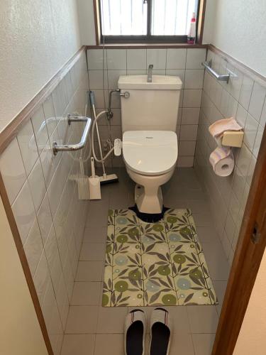 a bathroom with a toilet with a mat on the floor at The Pine 京都嵐山 in Kyoto
