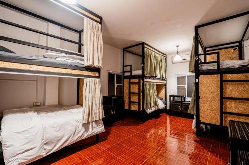um quarto com 2 beliches e piso em azulejo vermelho em ANOU HOSTEL em Pakse