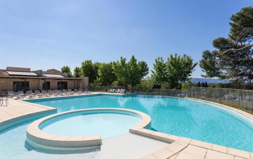 uma grande piscina com cadeiras ao redor em Appartement Golf de Saumane 2 chambres 2 à 4 personnes em Saumane-de-Vaucluse